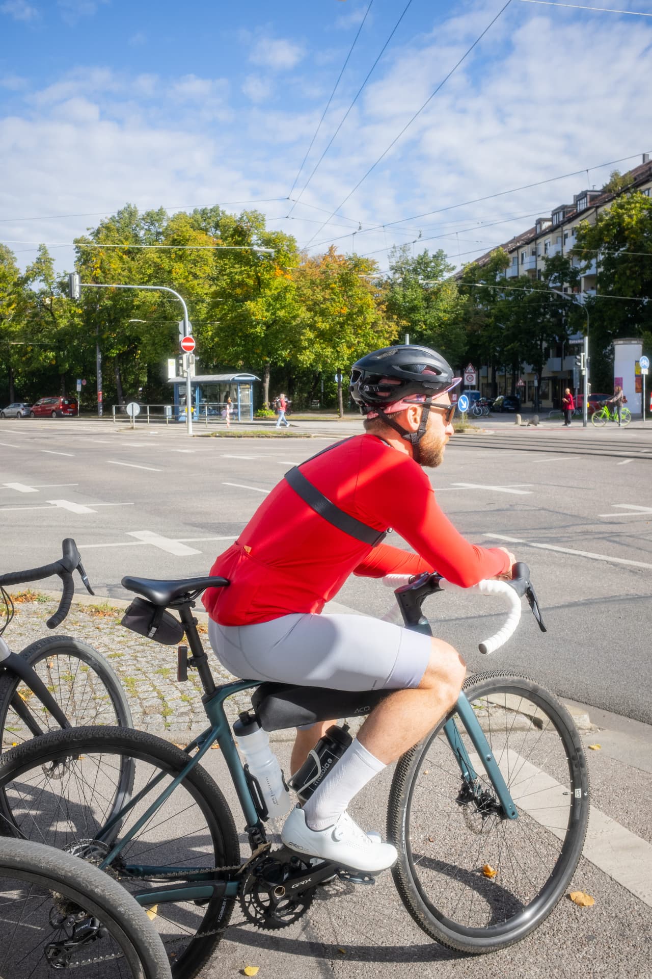 Fahrer im roten Trikot an einer Kreuzung in der Stadt